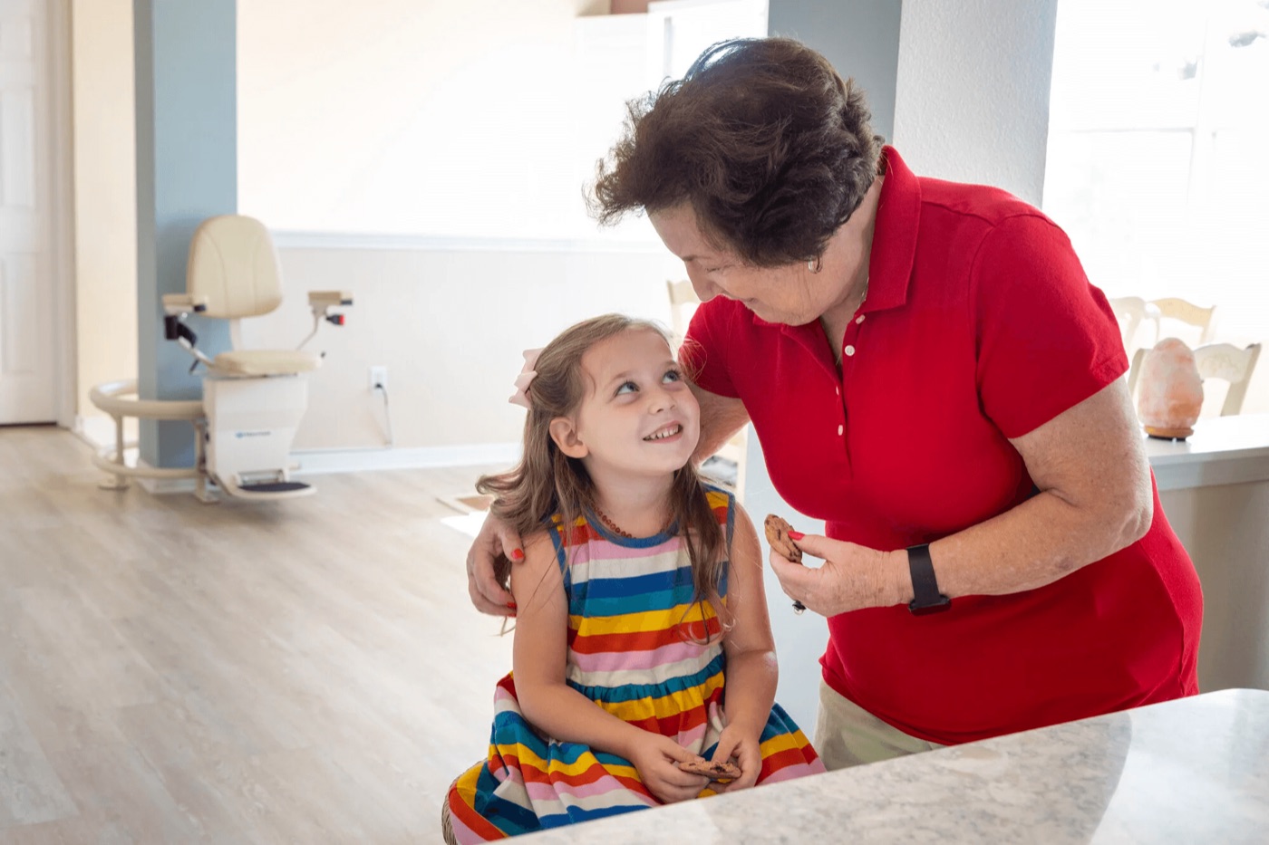 Grandmother and granddaughter at the base of a home stairlift